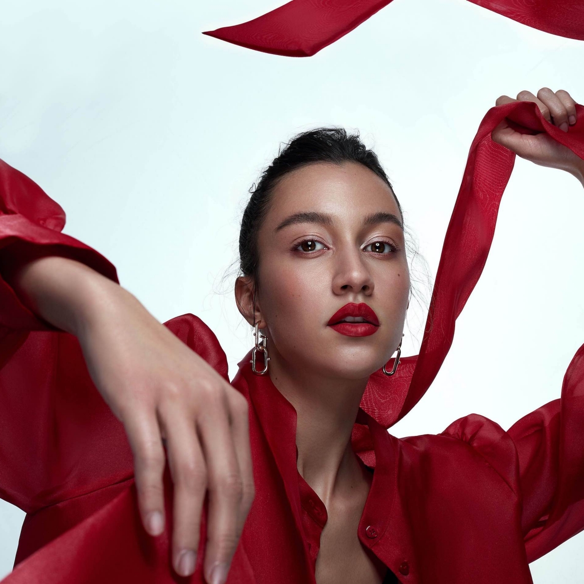 Alexis George wears a red blouse and matching red lipstick. 